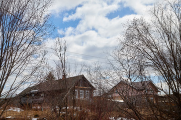 Obraz premium Old houses in the abandoned small village, branch of trees and sky with clouds background