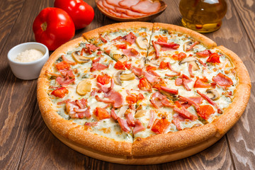 Delicious pizza with ingredients served on wooden table