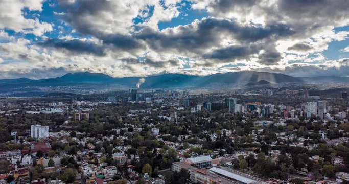 Aerial hyperlapse of a beautiful neighborhood in Mexico City with clouds and lights rays.