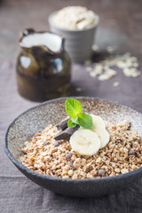 Healthy breakfast bowl. Granola with chocolate and banana on white wooden table. The concept of healthy nutrition and diet.