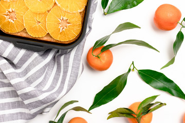 Orange-mandarin pie in baking dish on a striped linen towel