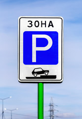 Parking sign against the blue sky