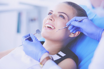 Fototapeta premium Young Female patient with open mouth examining dental inspection at dentist office.