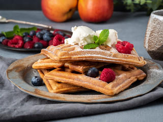 Belgian waffles with raspberries, chocolate syrup. Breakfast with tea on dark background, side...