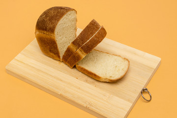 White bread, sliced, on wooden board.