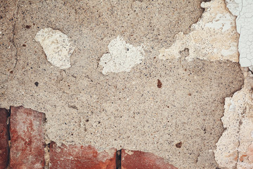 Old plastered wall with peeling paint as a background.