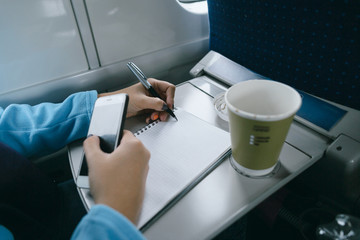 Women working in train Women hands writing in notebook