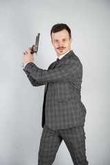 vintage English detective with a checkered business suit with a gun on a white studio solid background