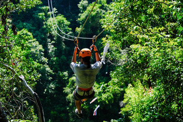 Men are playing zip line. © Attapol