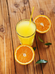 Fresh orange juice in glass on wooden background