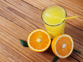 Fresh orange juice in glass on wooden background