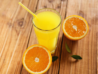 Fresh orange juice in glass on wooden background