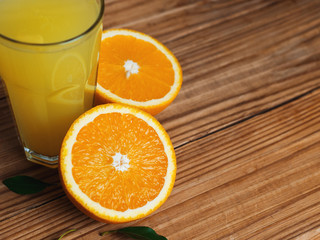 Fresh orange juice in glass on wooden background