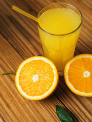 Fresh orange juice in glass on wooden background