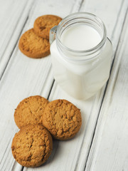 Milk with cookies on wooden white background