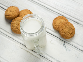 Milk with cookies on wooden white background