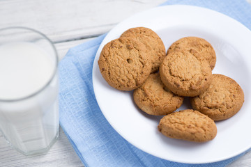 oatmeal cookies with milk on wooden background