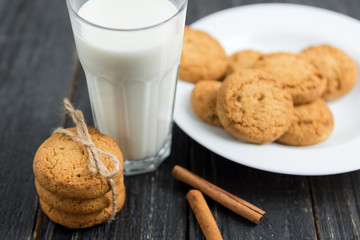 oatmeal cookies with milk on wooden background