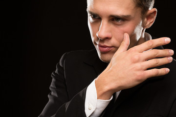 Cropped close up of a handsome young man posing expressively on black background looking to the camera confidently copyspace masculinity power seduction sexuality macho face touch hand