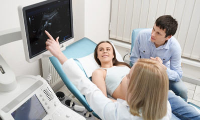 Obraz premium Doctor on consultation with pregnant woman and her husband.