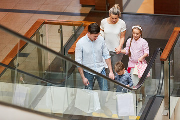 Familie beim Shopping auf einer Rolltreppe