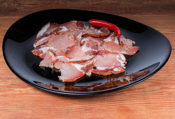 Thin slices of dried pork and chili on black dish