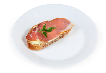 Open sandwich with cured pork decorated with greens on dish