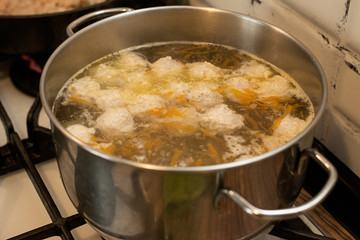 soup with meatballs in the pan on the stove