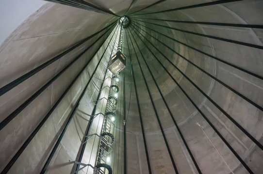 The elevator of a wind turbine slowly ascends within the massive concrete hybrid tower