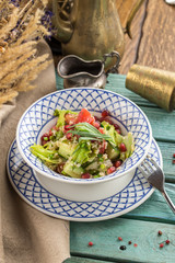 Delicious vegetarian quinoa salad with bell pepper, cucumber and tomatoes on blue wooden table