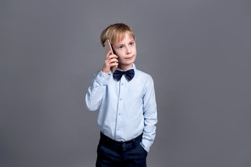 the young businessman talking on the phone,Little boy posing on a gray background.