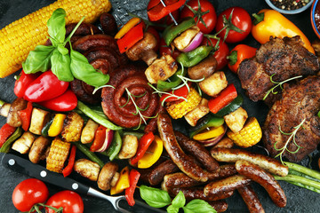 Assorted delicious grilled meat and skewer with vegetable on rustic table