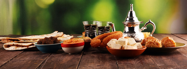 Middle eastern or arabic dishes and assorted meze, concrete rustic background. Turkish Bread or Turkish pizza. Dessert Baklava with pistachio. falafel with hommos.  Halal food. Lebanese cuisine