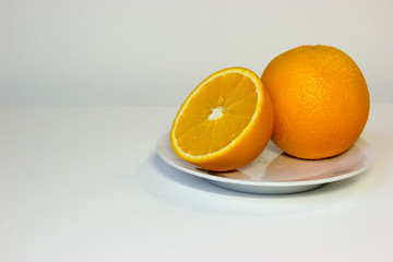 Isolated oranges on plate on white background
