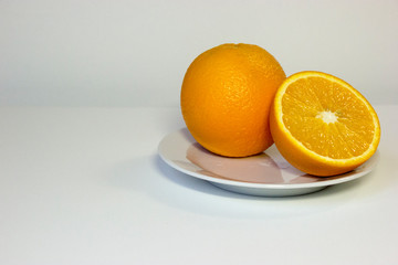 Isolated oranges on plate on white background