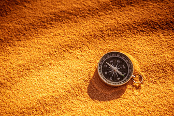 metal compass on sand