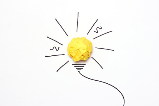  creative concept "idea", a new idea. Painted light bulb with a crumpled paper yellow ball.