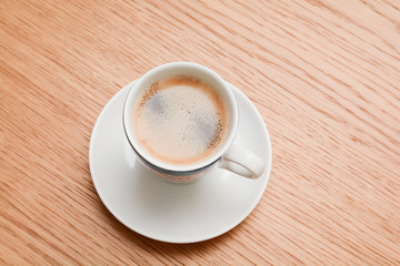 Espresso in a white cup on wooden table