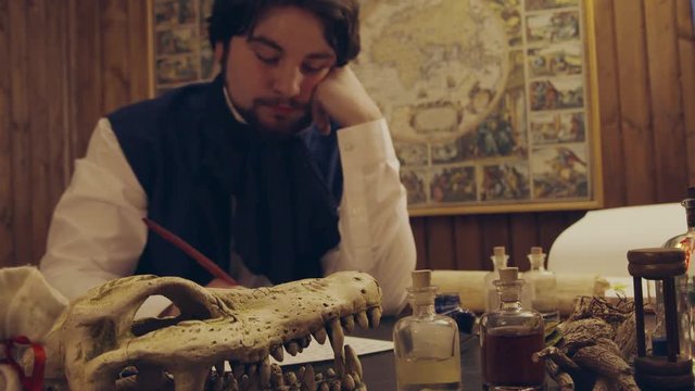 Young man writing letter in mystical office