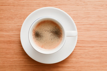 Espresso in a white cup on wooden table