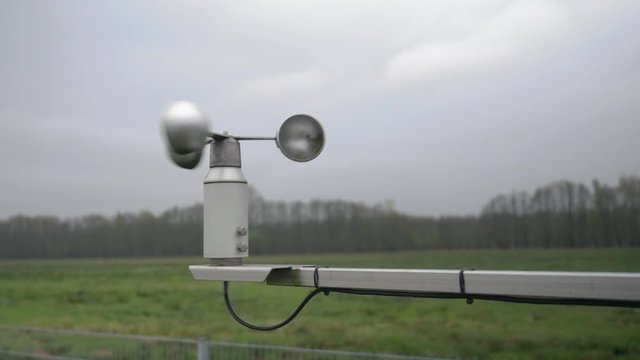 medium shot of an anemometer spining in the wind at an environmental measuring site.