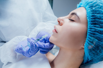 Lip Augmentation. Beautiful Young Woman's Mouth Receiving Hyaluronic Acid Injection. Closeup Of...