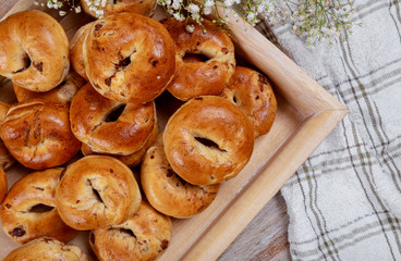 A tray of homemade traditional buns, the yellow buns have raisins and cinnamon