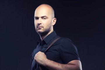 Obraz premium Young man, bald head, studio portrait. Dark background