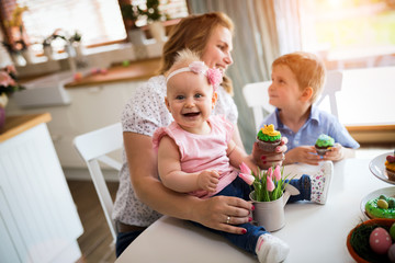 Happy easter. A mother and her kids painting Easter eggs