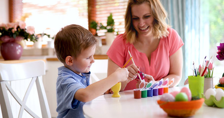 Obraz na płótnie Canvas Mother and son are painting eggs