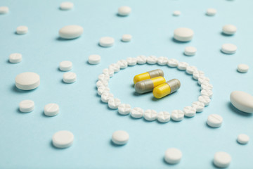 White pills for pain relief and treatment on a blue background.