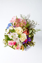 Photo from above of romantic bouquet of pink roses, lilies, green leaves with postcard isolated .