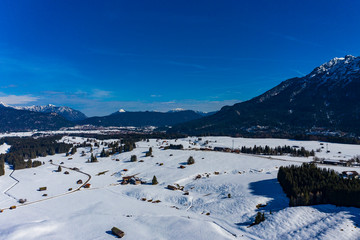 Fototapeta na wymiar Aerial view, Mittenwald snowy meadow, Alps and Karwendel mountains, Bavaria, Germany