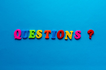 Fototapeta premium text questions from plastic colored letters on blue paper background